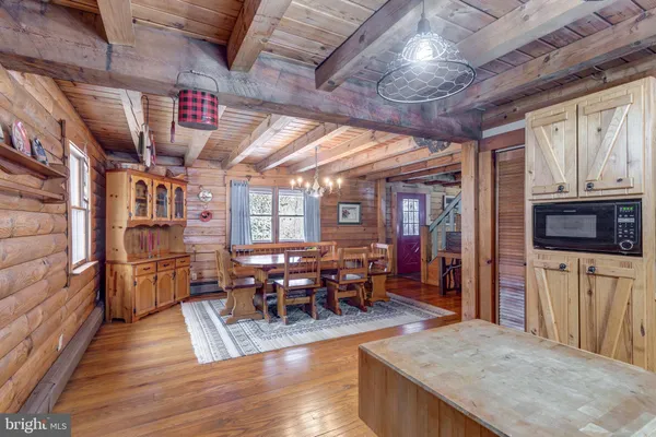 a kitchen with stainless steel appliances granite countertop a table chairs and a refrigerator