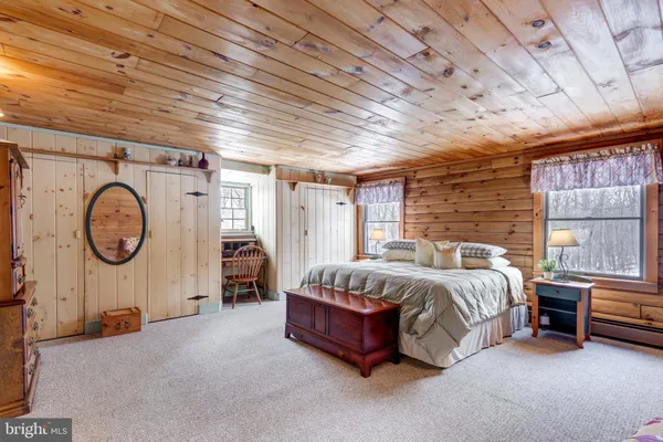 a bathroom with a toilet a sink and wooden floor