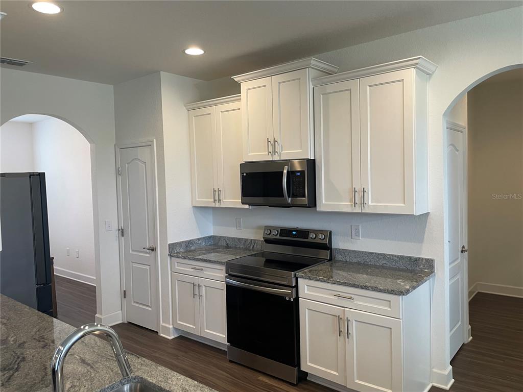 33 Deer Road Frostproof, FL 33843 - Photo 22 of 64 a kitchen with stainless steel appliances granite countertop a stove a sink and a refrigerator