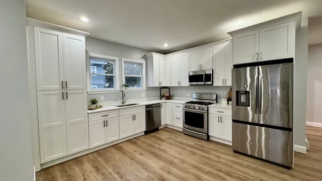 a kitchen with stainless steel appliances granite countertop a refrigerator stove and microwave