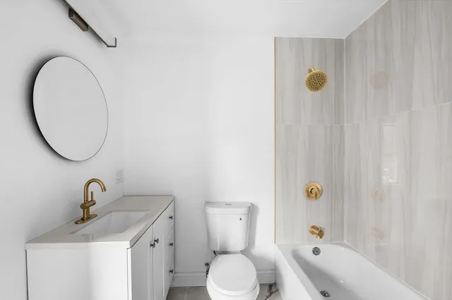 a view of a hallway with wooden floor and a living room