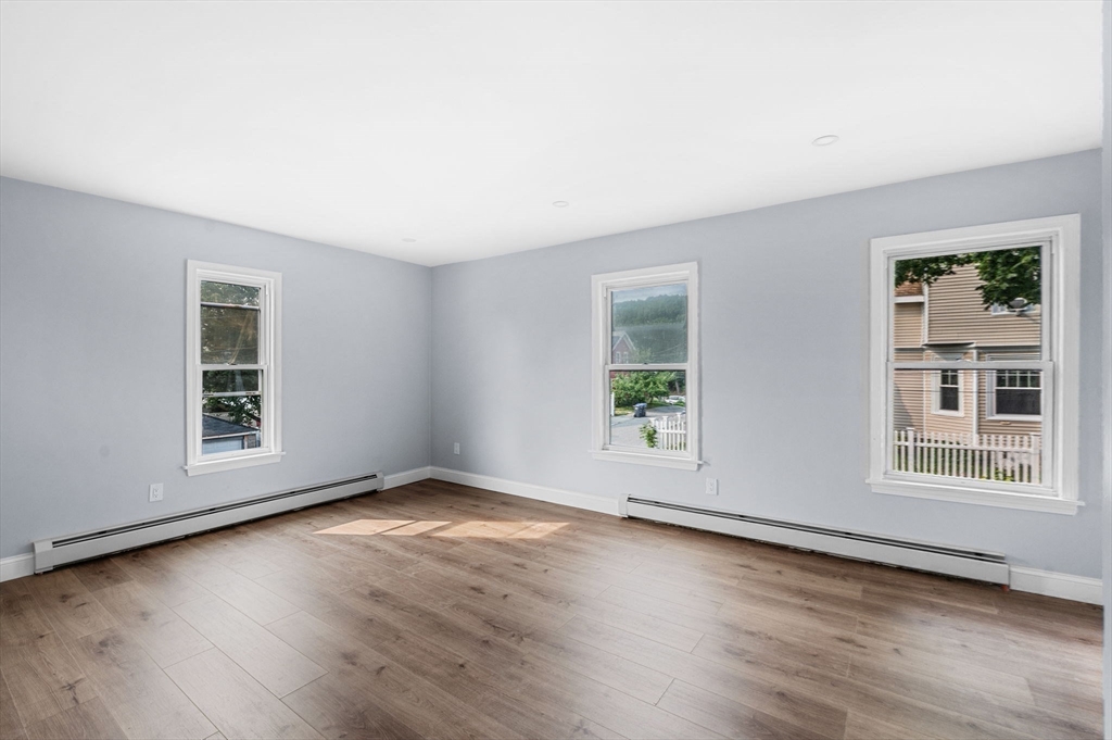 83 Arnold Street Methuen, MA 01844 - Photo 28 of 42 an empty room with wooden floor and windows