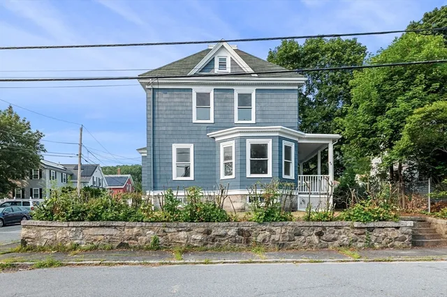 a front view of a house with a yard and potted plants