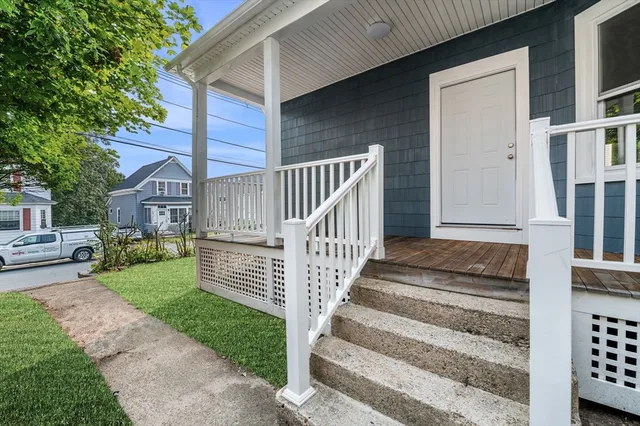 a view of house with wooden deck and a garden