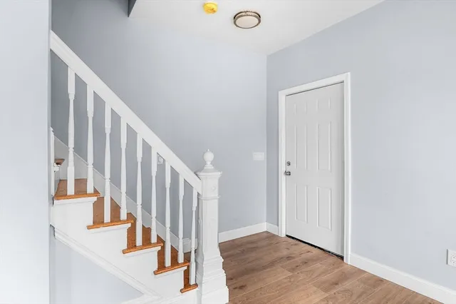 a view of staircase with lots of frames on wall and wooden floor
