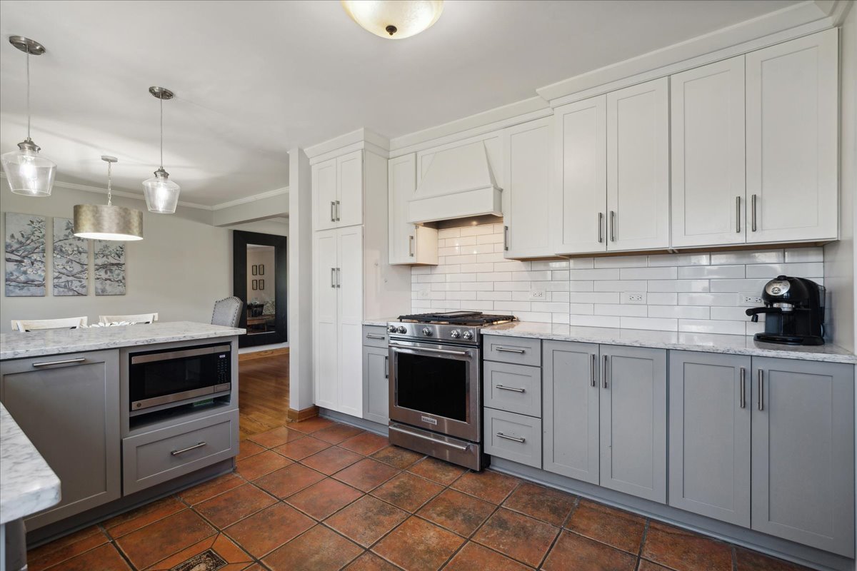 203 Pine Street Deerfield, IL 60015 - Photo 8 of 24 a kitchen with stainless steel appliances granite countertop a stove and white cabinets