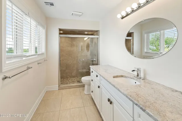 a spacious bathroom with a granite countertop sink mirror and a bathtub