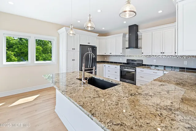 a kitchen with stainless steel appliances granite countertop a sink counter space cabinets and a large window