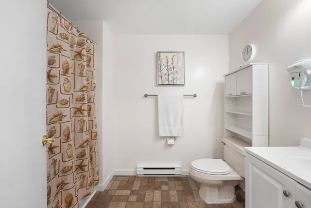 a bathroom with a granite countertop toilet and a sink