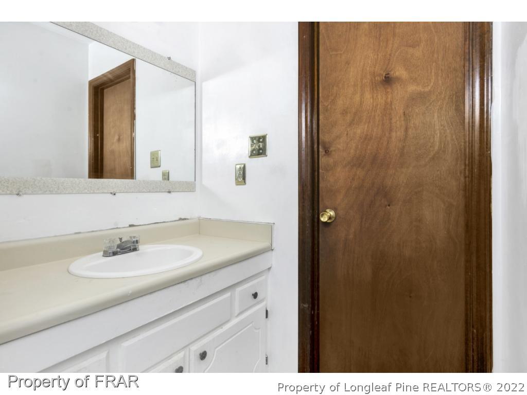 1758 Rim Road Fayetteville, NC 28314 - Photo 12 of 25 a bathroom with a sink and a mirror