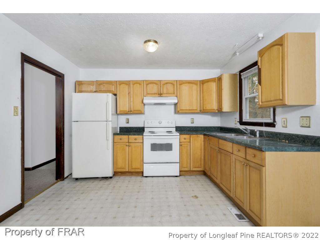 1758 Rim Road Fayetteville, NC 28314 - Photo 7 of 25 a kitchen with a refrigerator and a sink