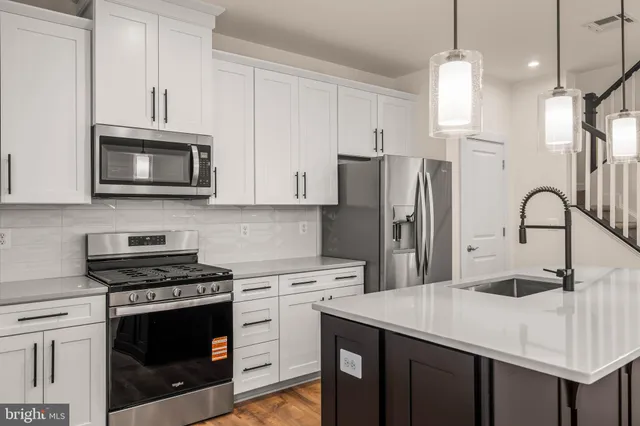 a kitchen with stainless steel appliances a stove microwave and a refrigerator
