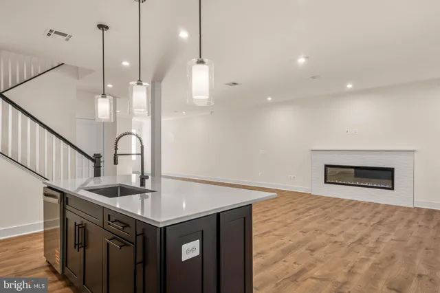 a kitchen with stainless steel appliances granite countertop a sink a oven a refrigerator and a wooden floors