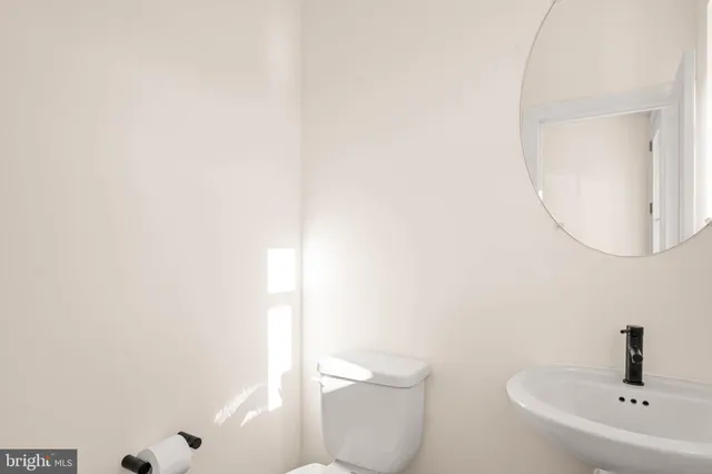 a bathroom with a toilet a sink and mirror