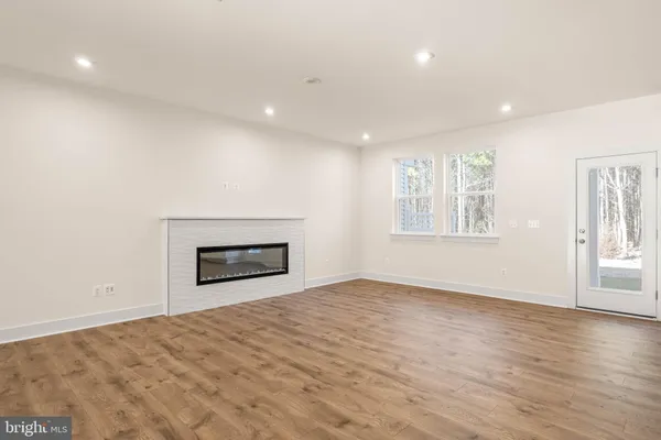 a view of a big room with wooden floor and windows