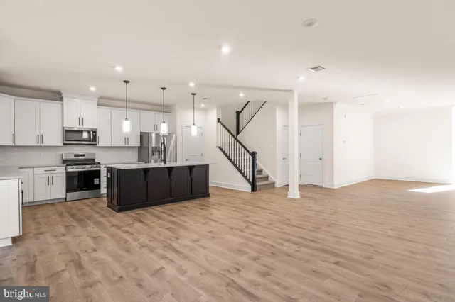 a kitchen with stainless steel appliances kitchen island granite countertop a sink and cabinets