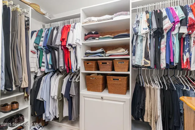 a view of walk in closet with clothes and shoes