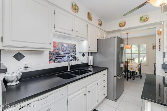 a kitchen with stainless steel appliances a sink a stove and white cabinets