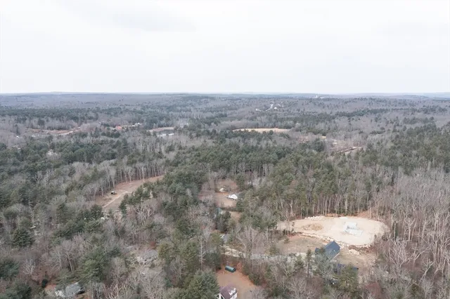 an aerial view of a house with a yard and mountain view in back