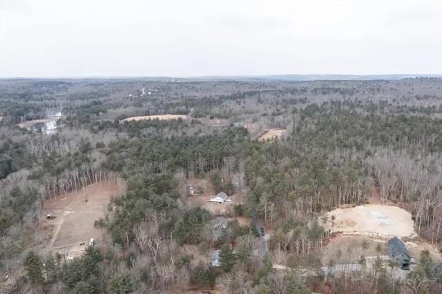 an aerial view of house with yard and mountain view in back