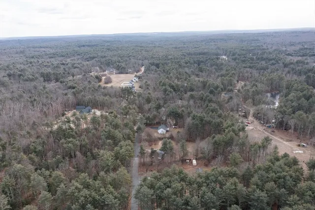 an aerial view of house with yard and mountain view in back