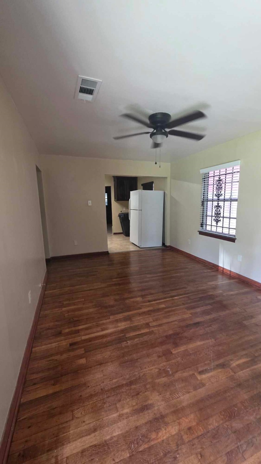 4532 Briscoe Street Houston, TX 77051 - Photo 7 of 14 a view of an empty room with a window and wooden floor
