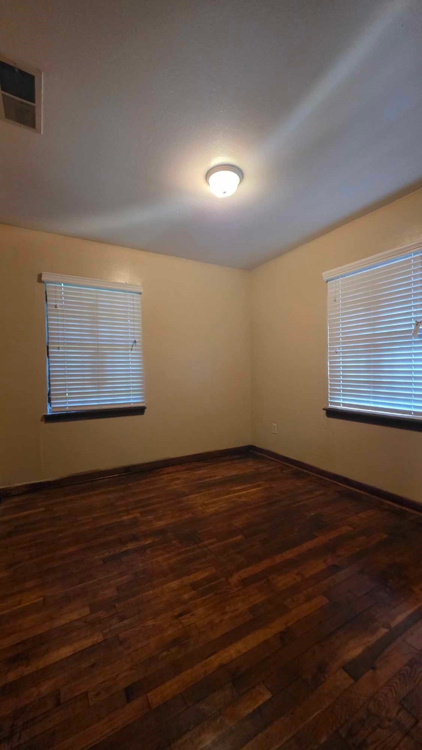 4532 Briscoe Street Houston, TX 77051 - Photo 10 of 14 a view of an empty room with wooden floor and a window