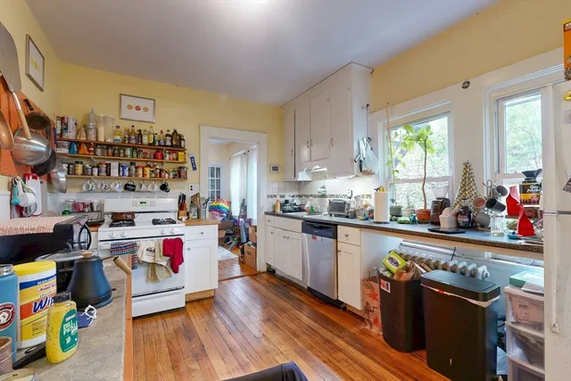 a bedroom with a bed a computer on the desk and a book shelf