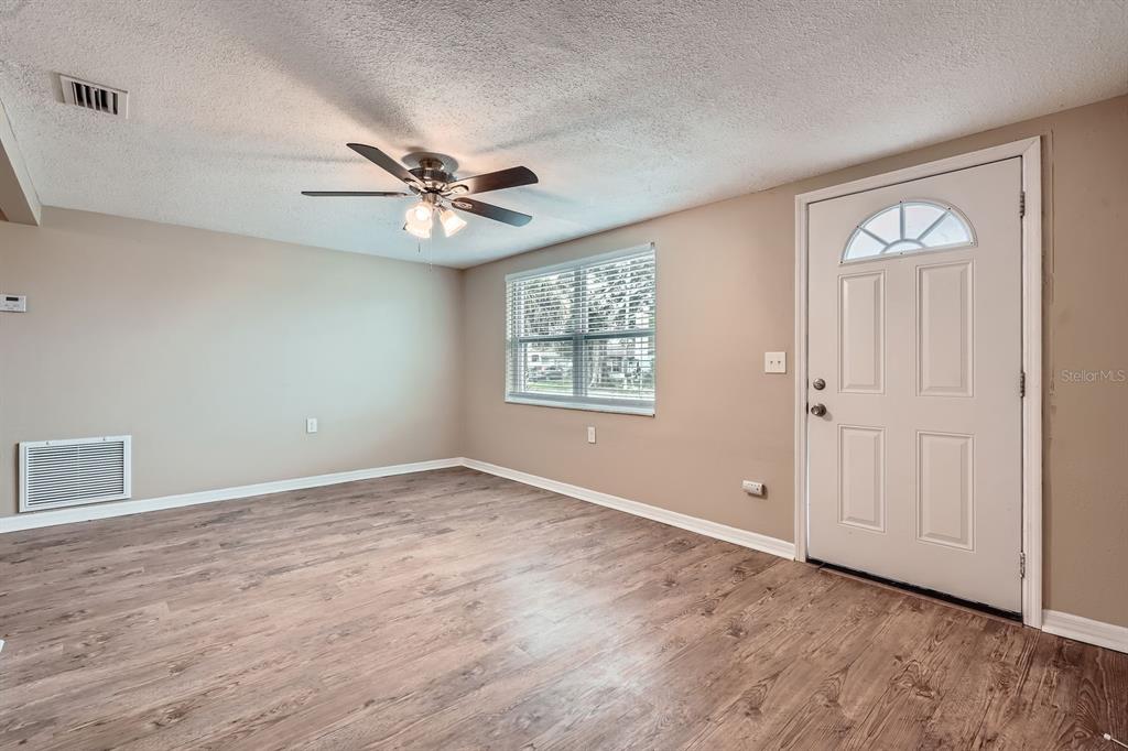 5429 Flora Avenue Holiday, FL 34690 - Photo 11 of 33 an empty room with windows and fan