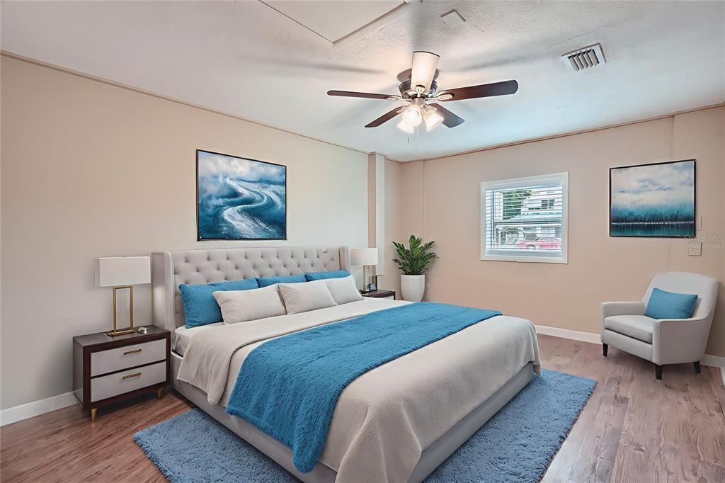 5429 Flora Avenue Holiday, FL 34690 - Photo 16 of 33 a bedroom with a bed and a chandelier