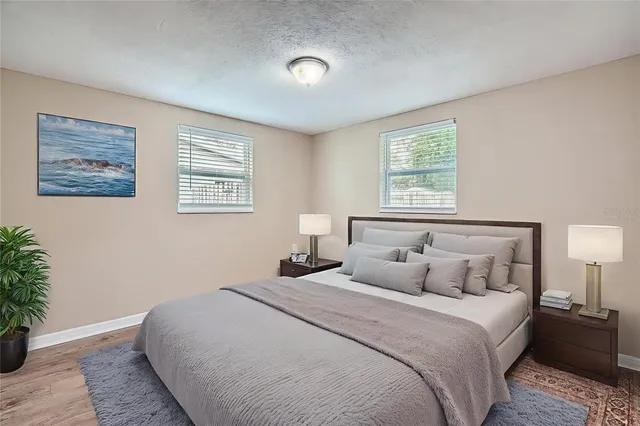 a bedroom with a large bed and a potted plant