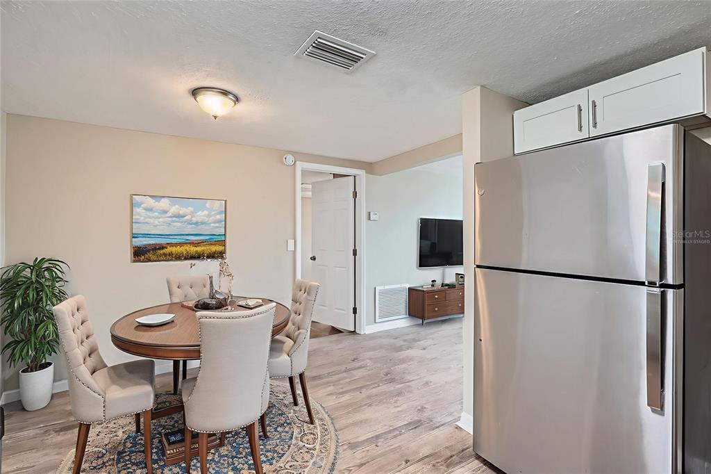 5429 Flora Avenue Holiday, FL 34690 - Photo 8 of 33 a dining room with furniture a refrigerator and a table