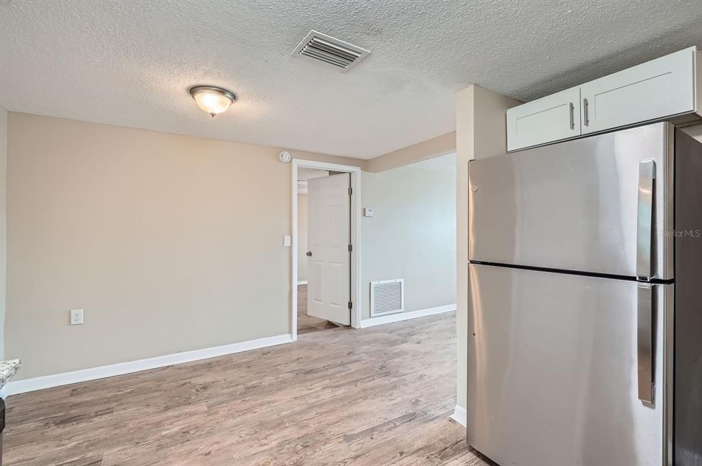5429 Flora Avenue Holiday, FL 34690 - Photo 9 of 33 a view of an empty room with wooden floor and a refrigerator