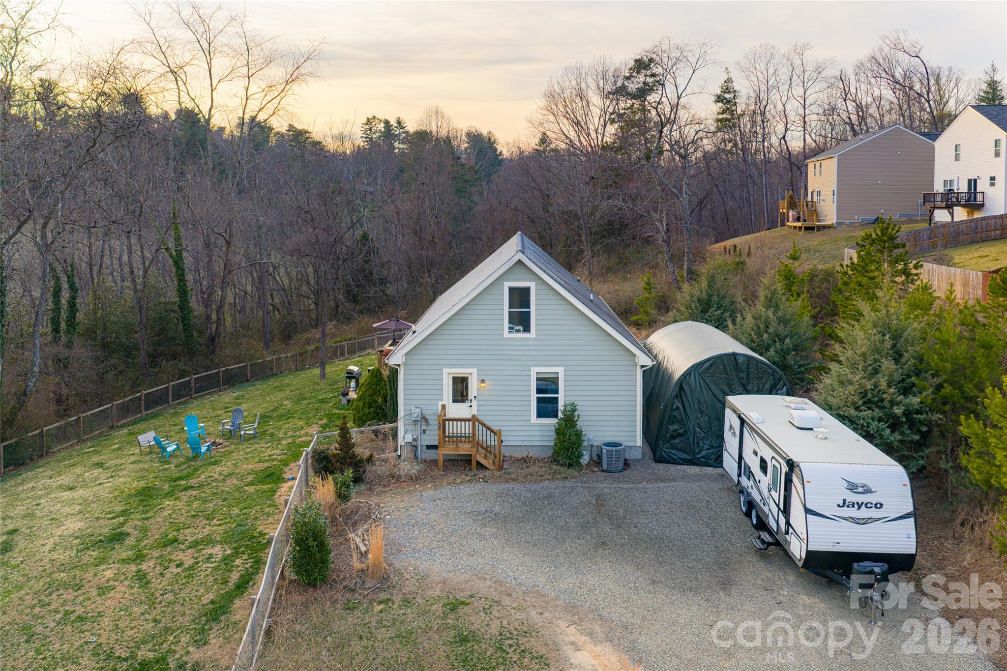 a view of a house with a backyard and trees
