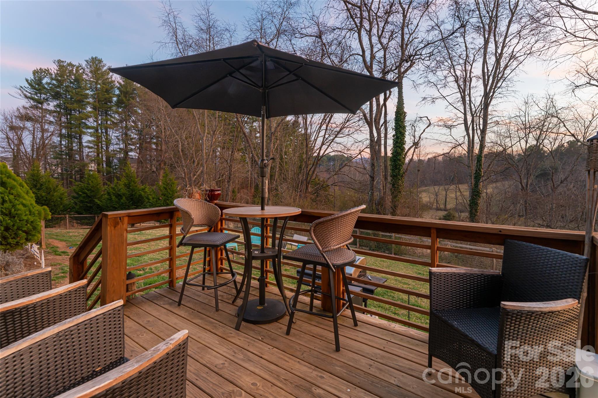 65 Owenby Road Candler, NC 28715 - Photo 12 of 48 a view of a roof deck with table and chairs under an umbrella