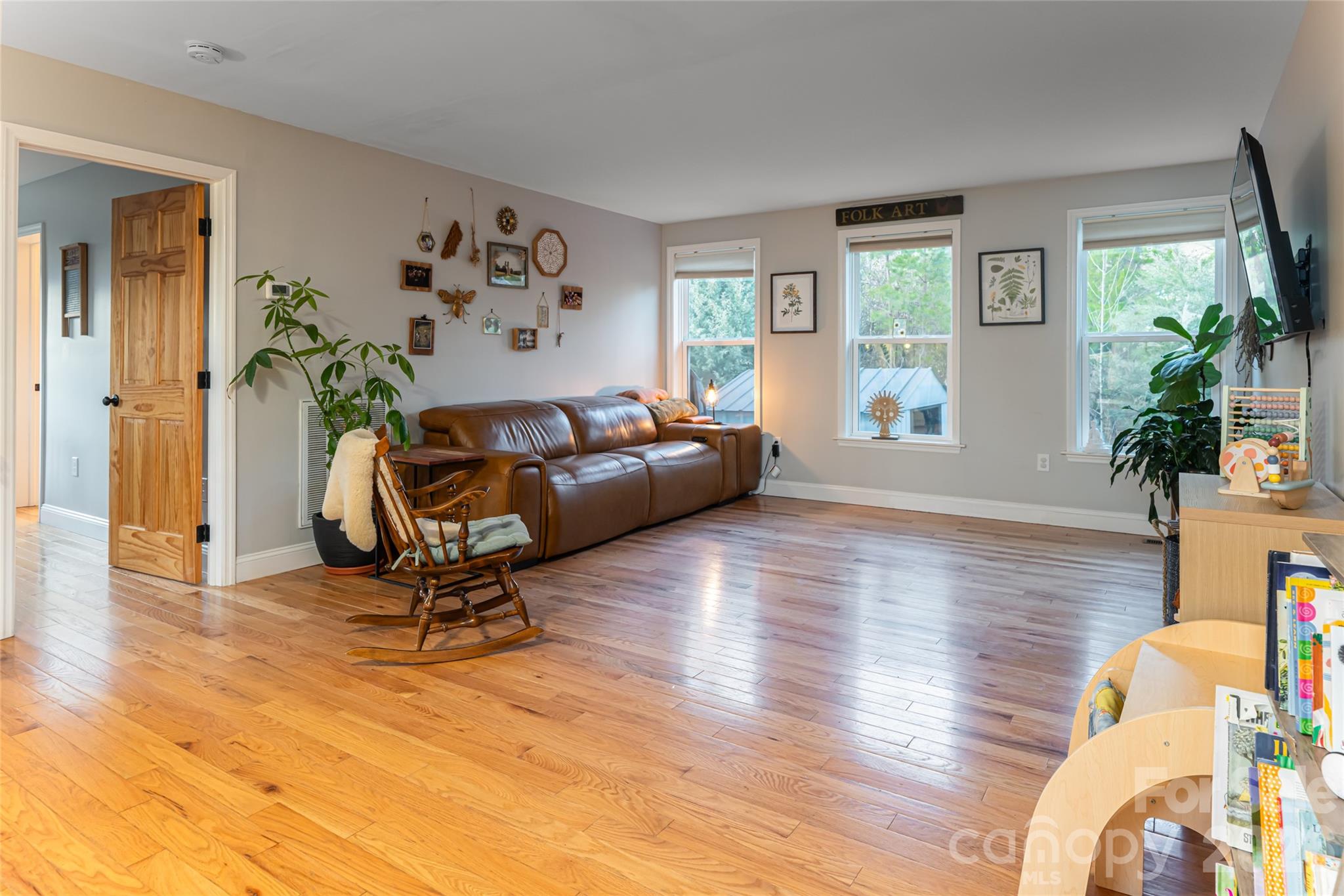65 Owenby Road Candler, NC 28715 - Photo 18 of 48 a view of a livingroom with furniture a potted plant and wooden floor