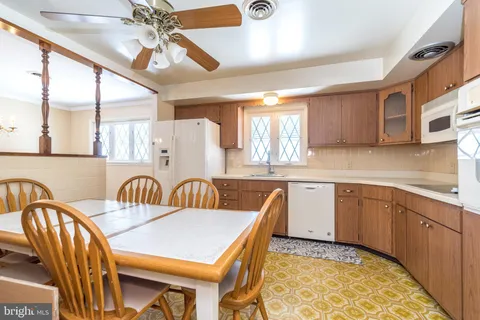 a kitchen with stainless steel appliances granite countertop a sink a stove a dining table and chairs with wooden floor
