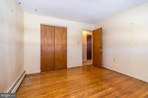 an empty room with wooden floor and closet