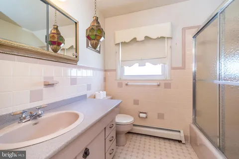 a bathroom with a sink a toilet and a window