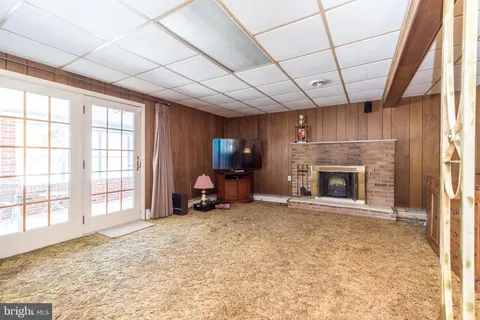 a view of an empty room with a fireplace and a window