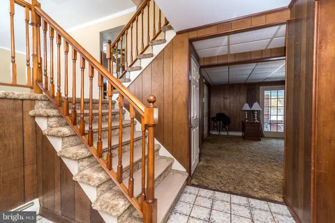 a view of staircase with lots of frames on wall and a window