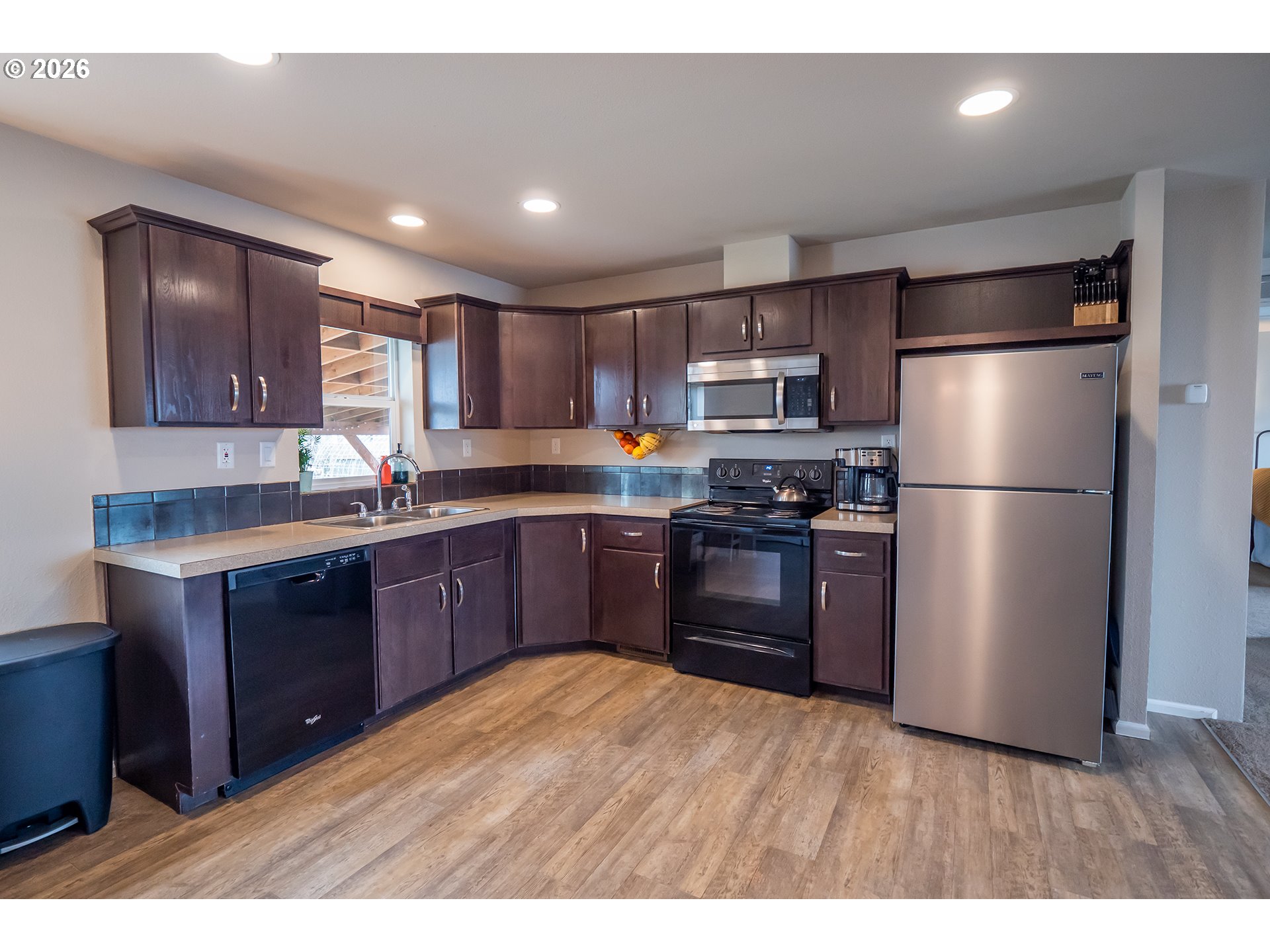 628 Stanley Lane Harrisburg, OR 97446 - Photo 10 of 32 a kitchen with stainless steel appliances granite countertop a refrigerator a sink dishwasher a stove with wooden floor