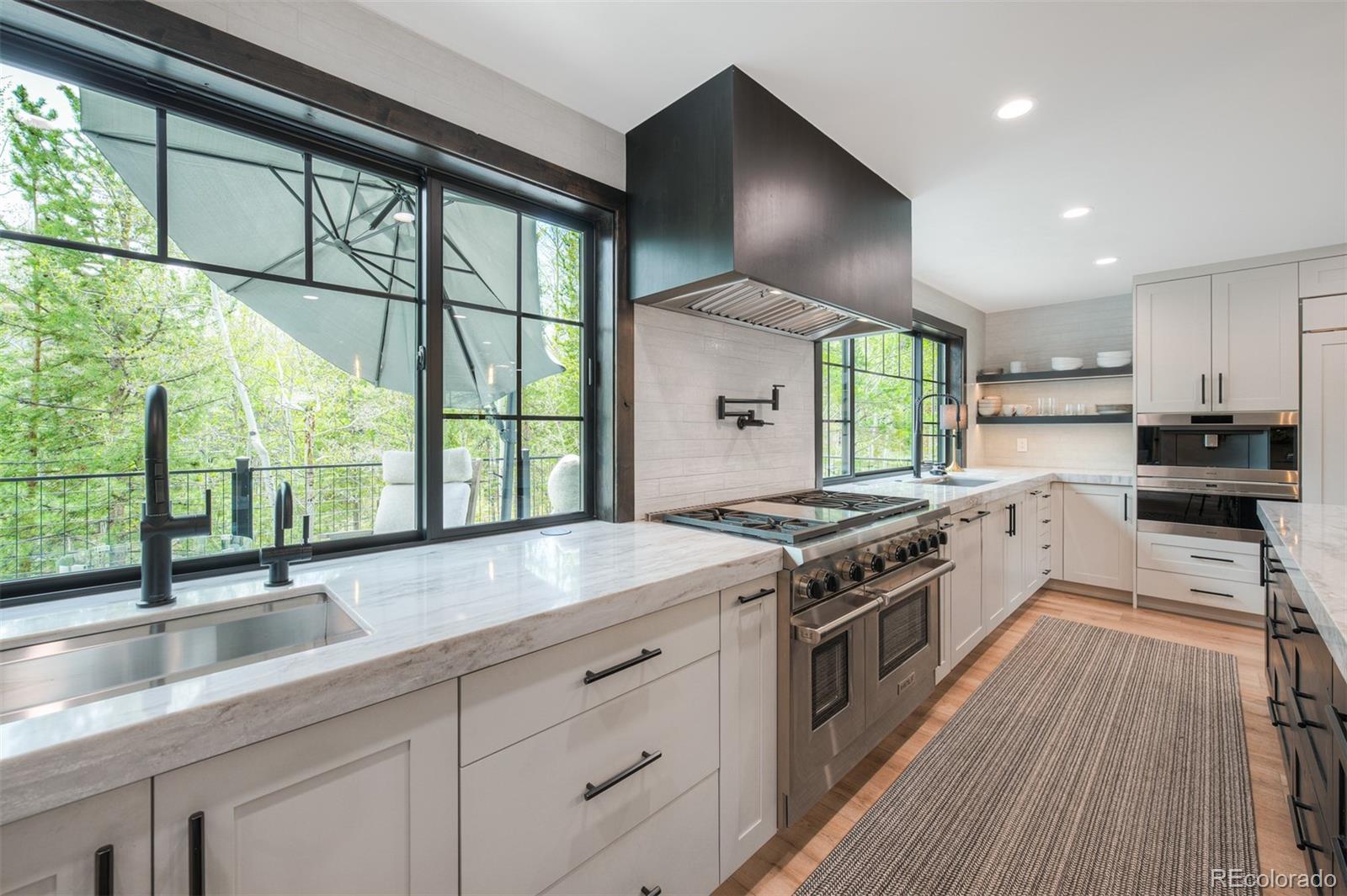 306 Golden Eagle Road Silverthorne, CO 80498 - Photo 8 of 43 a kitchen with stainless steel appliances granite countertop a stove a sink and a wooden floors