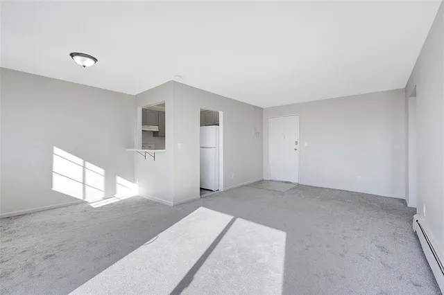 a view of empty room with wooden floor and a window