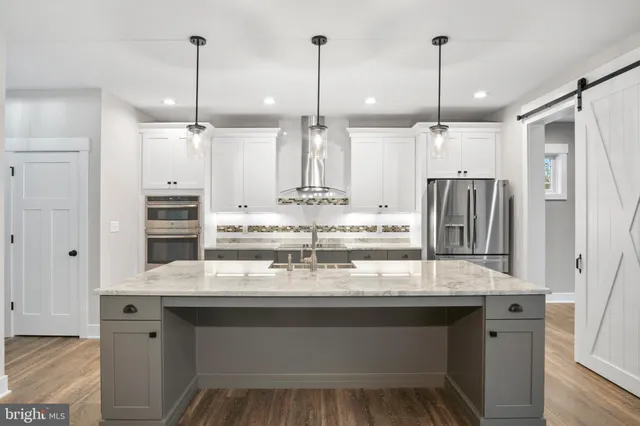 a kitchen with a sink stainless steel appliances and white cabinets