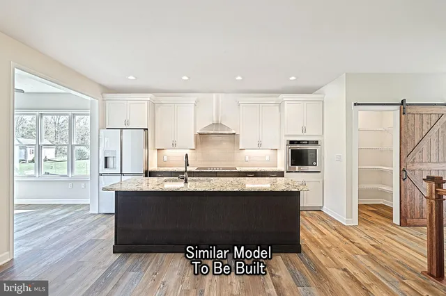 an empty room with wooden floor fireplace and windows