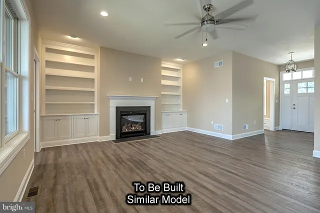 a view of hallway with window and wooden floor