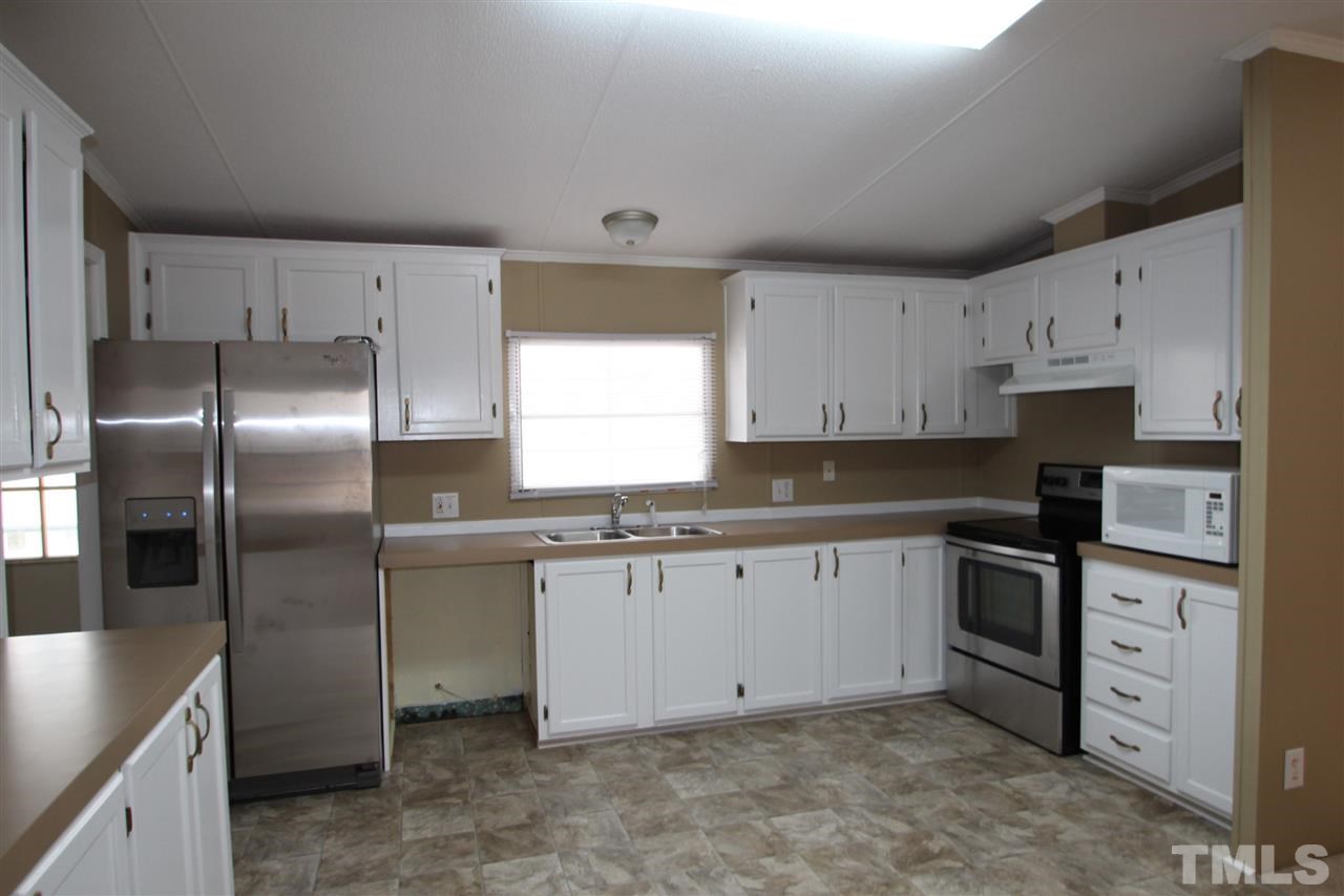 465 Melton Road Roxboro, NC 27574 - Photo 5 of 11 a kitchen with granite countertop a refrigerator sink and cabinets