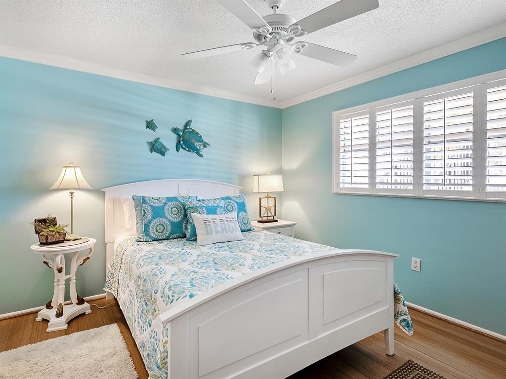 230 Santa Maria Street, Unit 234 Venice, FL 34285 - Photo 23 of 60 a bedroom with a bed and a chandelier