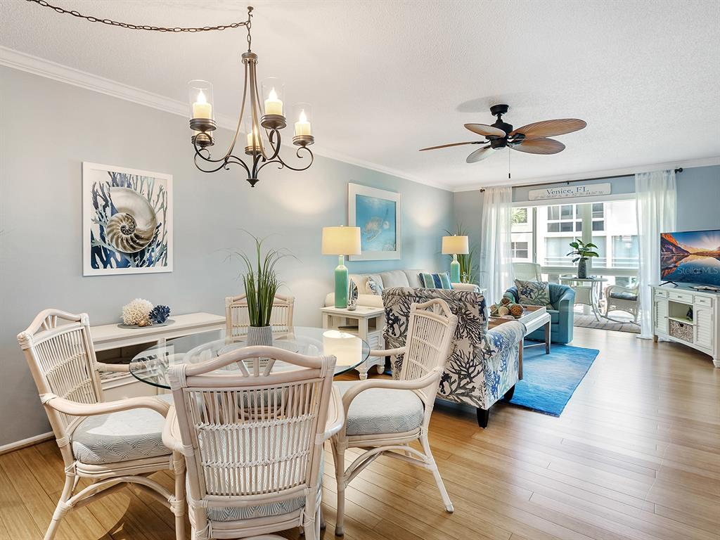 230 Santa Maria Street, Unit 234 Venice, FL 34285 - Photo 8 of 60 a view of a dining room with furniture a chandelier and wooden floor